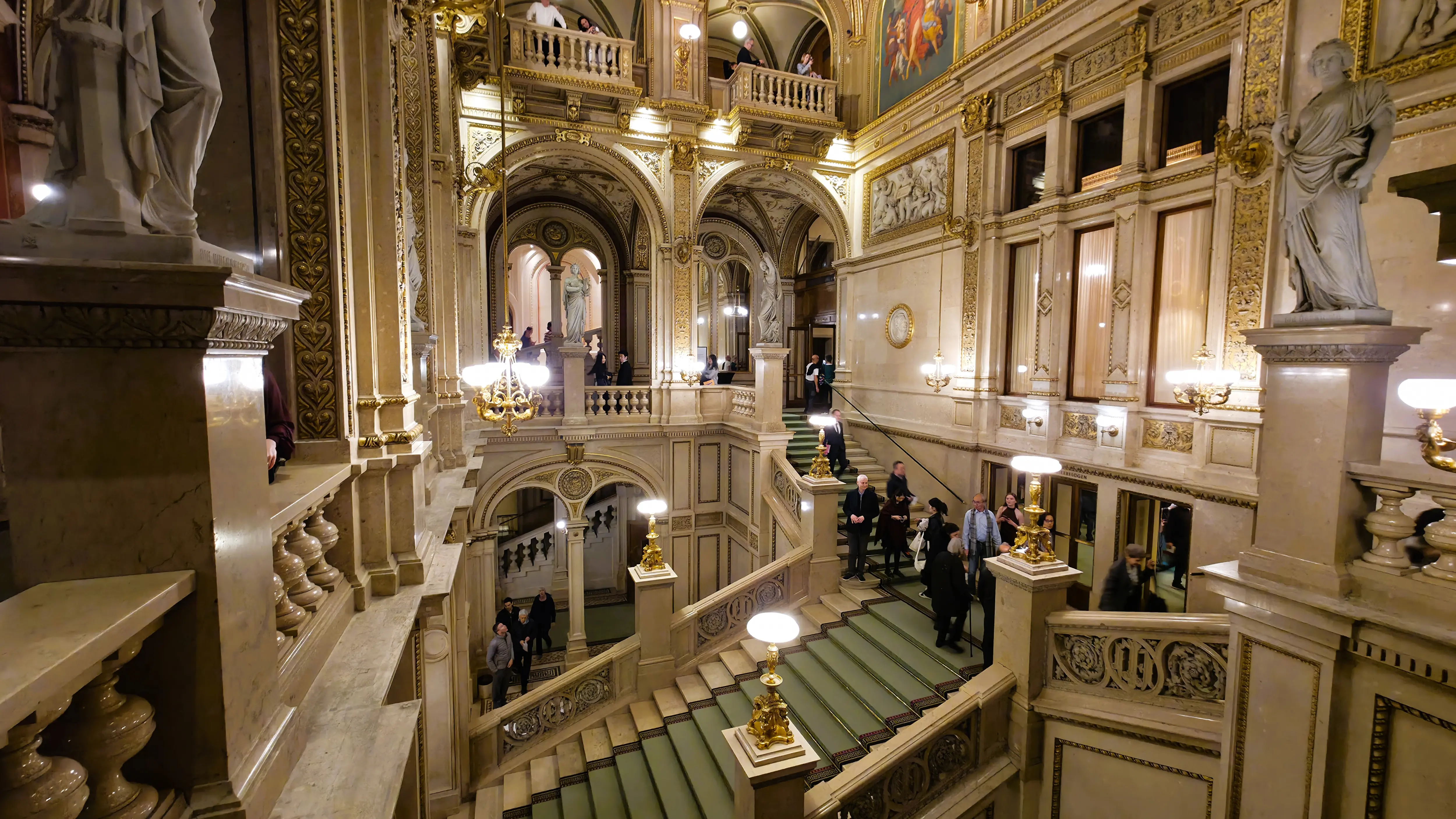 The grand staircase inside the Vienna State Opera in Vienna, Austria, with broad steps, warm lighting, and elegant detailing