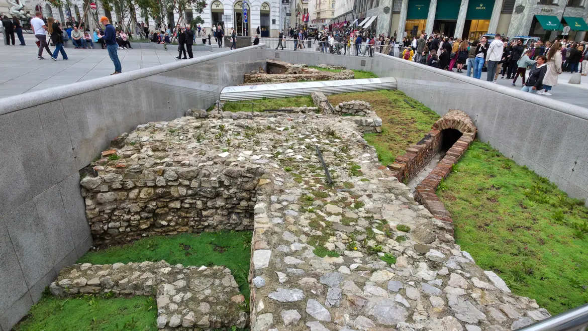 Roman ruins of Vindobona at Michaelerplatz surrounded by pedestrians and daily city life in Vienna