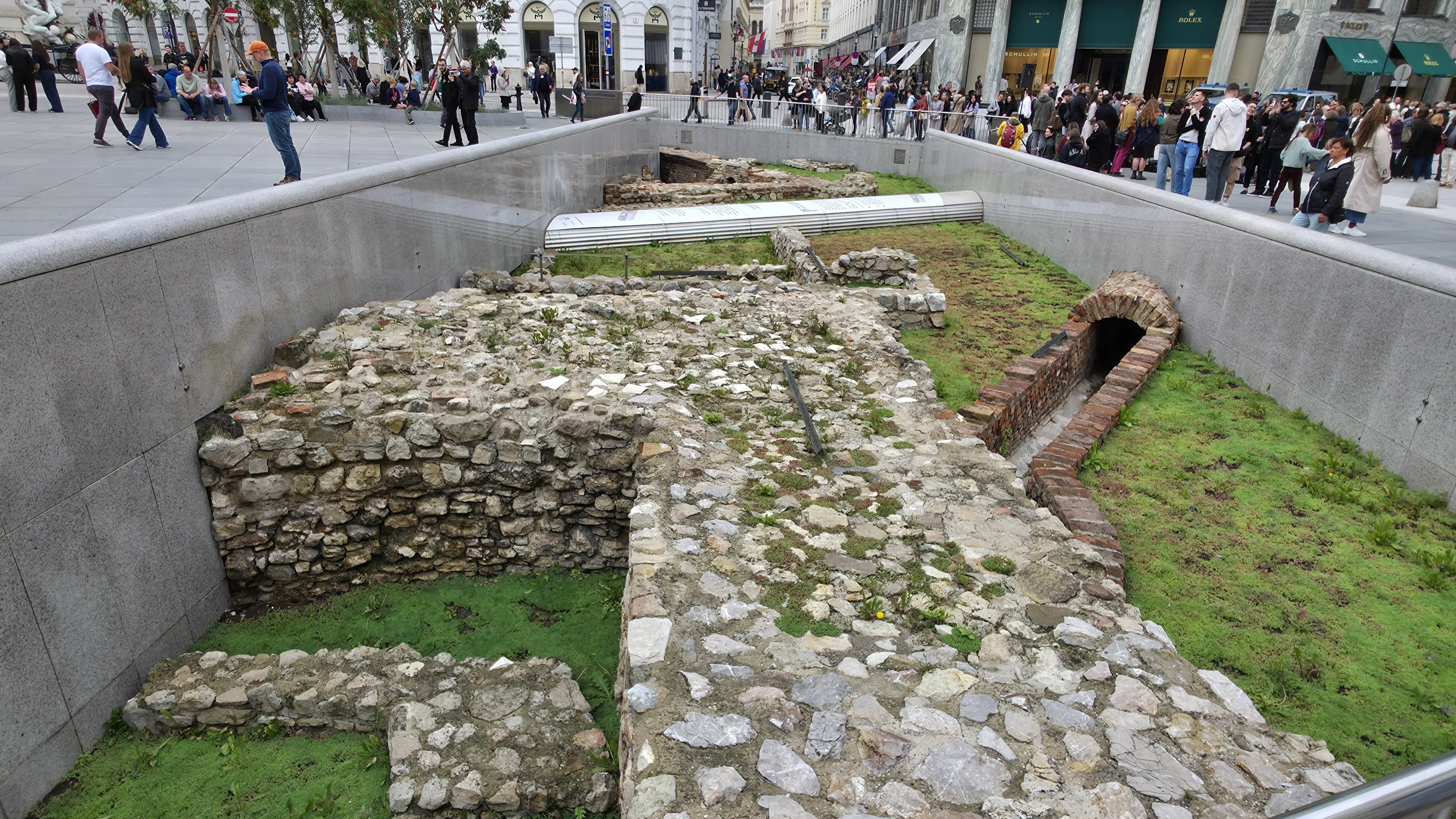 Roman ruins of Vindobona at Michaelerplatz in Vienna, surrounded by pedestrians and historic architecture