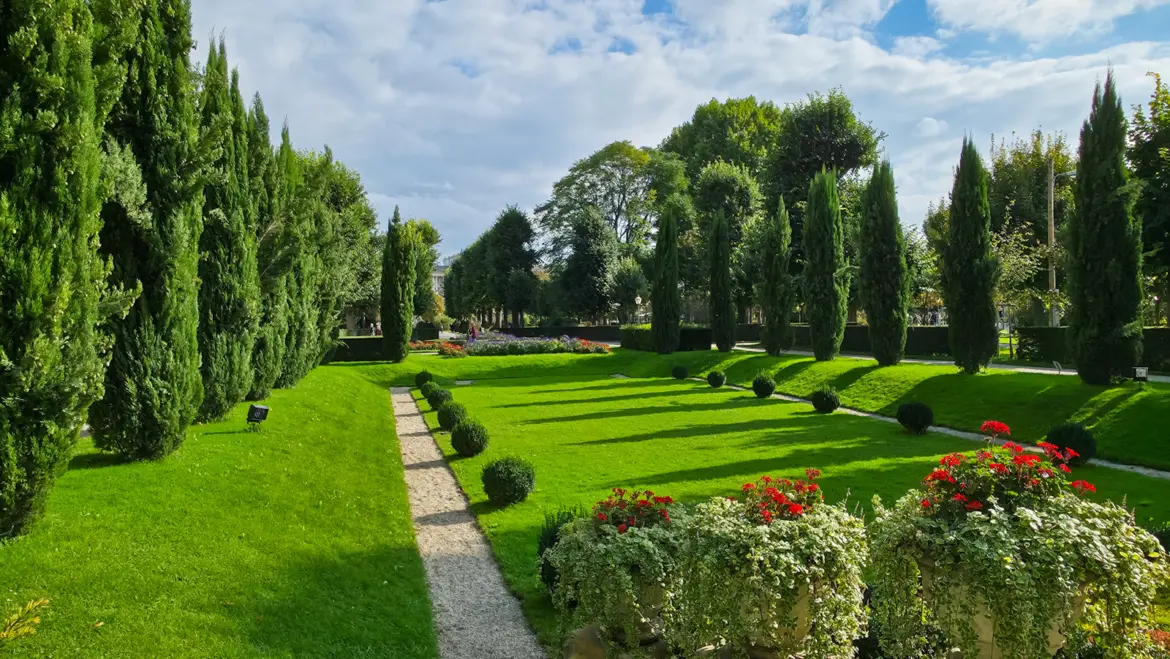 Landscaped view Volksgarten Vienna Austria featuring flowerbeds mature trees front monument Empress Elisabeth Austria gentle integration history nature memorial present without dominating