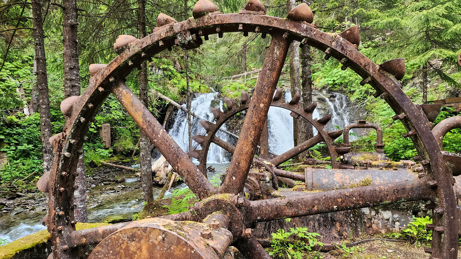 A historic mining water wheel from the Wagner Mine era along the Gold Creek nature walk in Juneau, Alaska