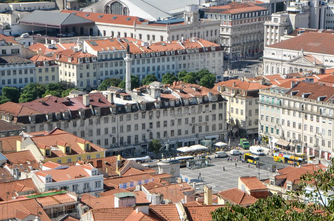 Aerial view of Praça da Figueira and Rossio Square in Lisbon's Baixa district with red-tiled rooftops and Pombaline architecture