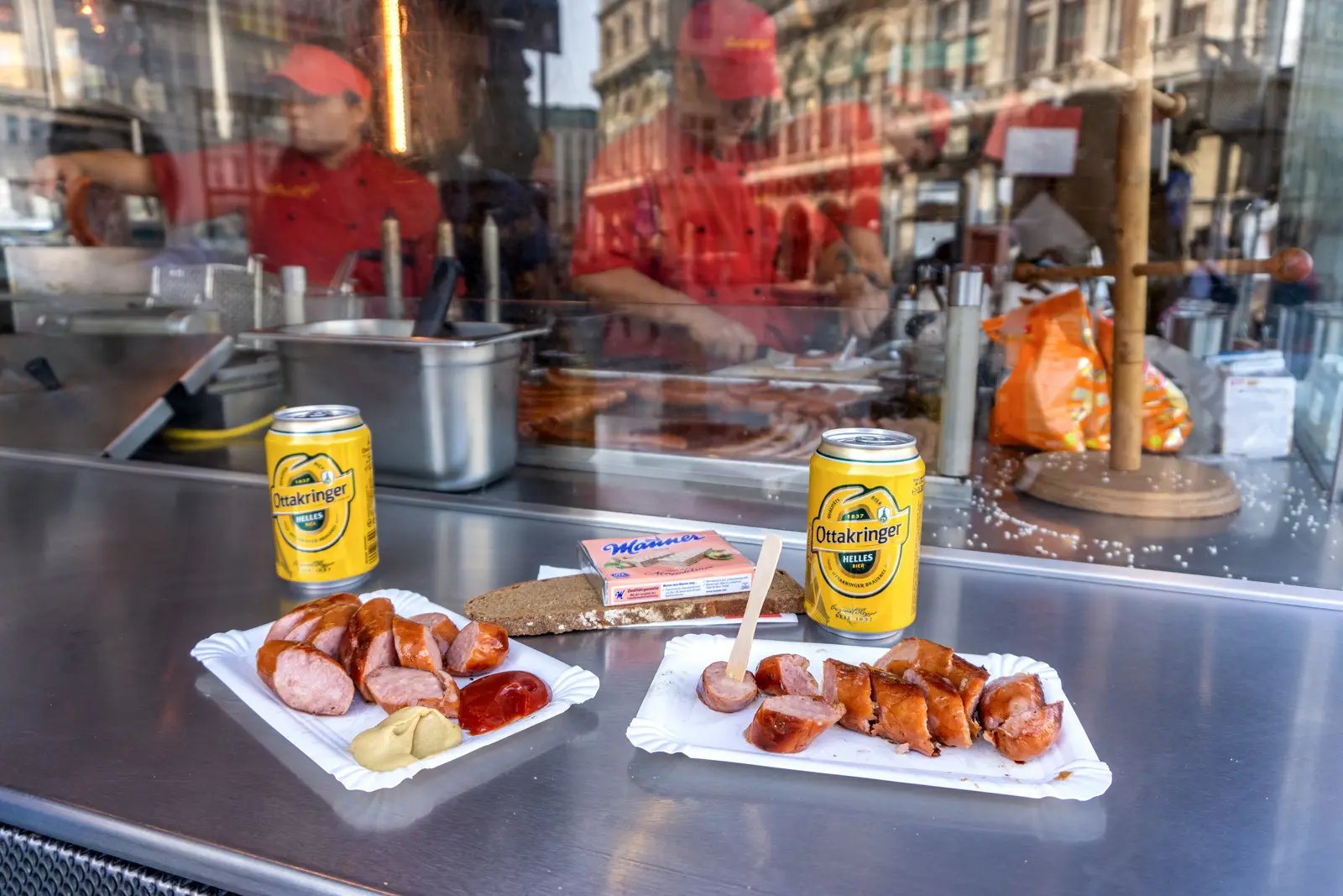 The counter at Bitzinger Würstelstand with freshly sliced sausages, mustard, and Ottakringer beer in Vienna