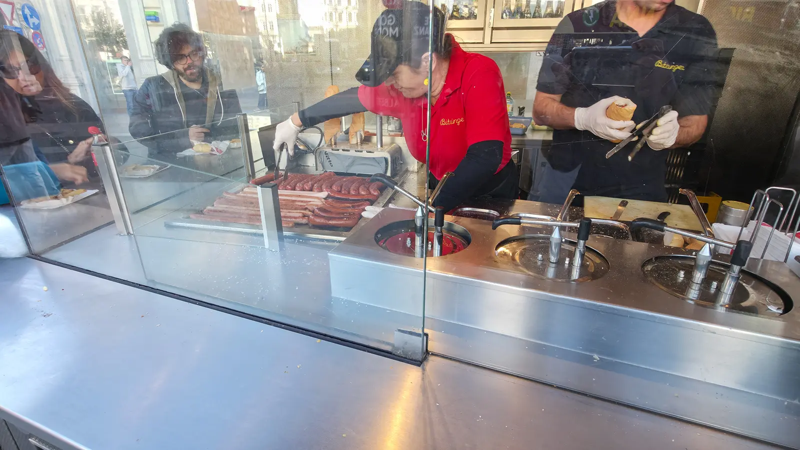 Staff preparing sausages at Bitzinger Würstelstand near the Albertina and Vienna State Opera
