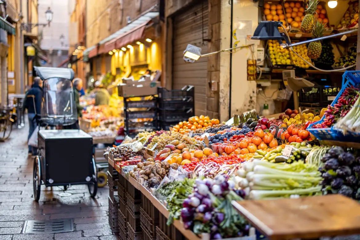 Colorful fruit and vegetable market stalls in Bologna, reflecting the city’s vibrant food culture and everyday Italian life