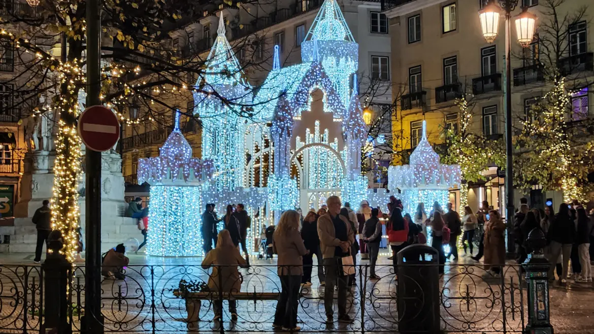 Spectacular illuminated Christmas castle light installation in Chiado Lisbon with crowds and festive atmosphere at night