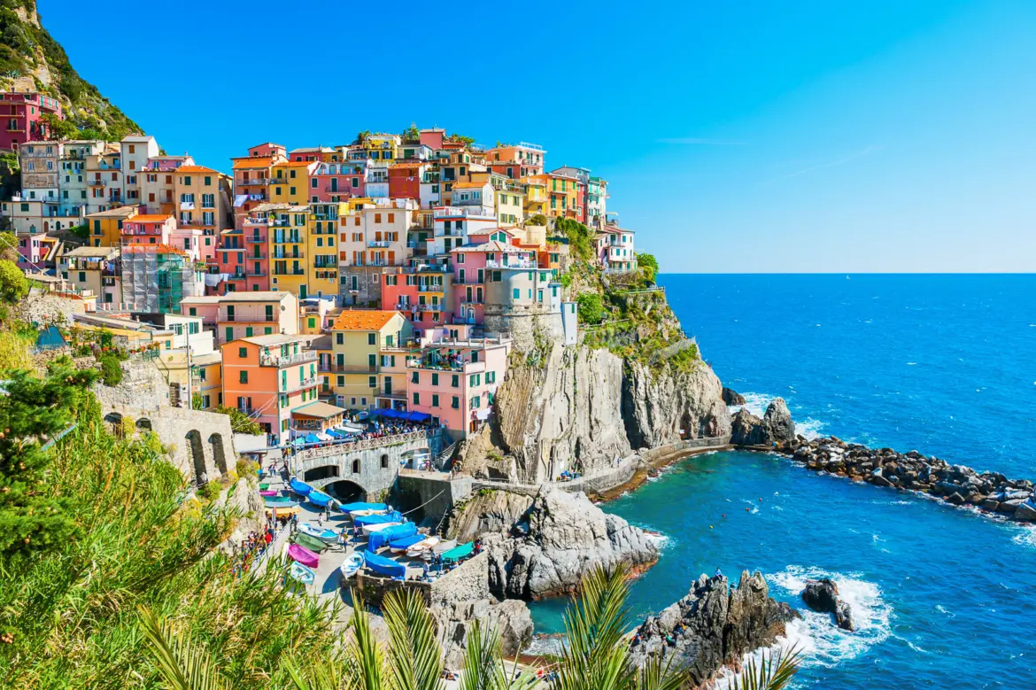 Colorful Cinque Terre coastline with pastel villages perched above the turquoise Ligurian Sea, one of the most scenic day trips from Florence