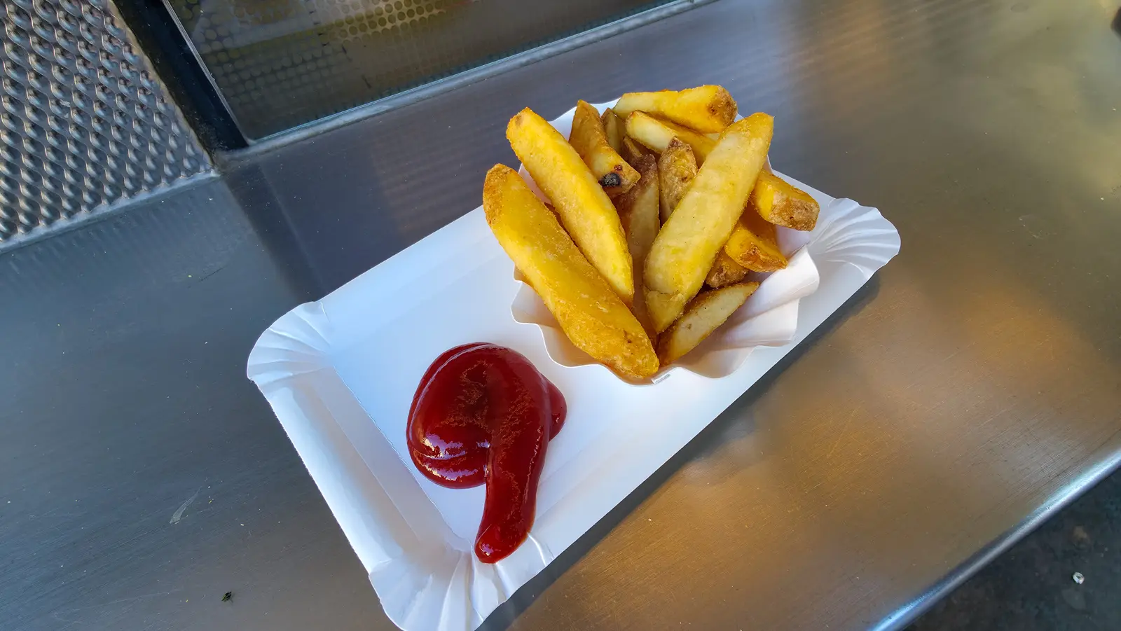 Crispy golden fries served with ketchup at Bitzinger Würstelstand in Vienna
