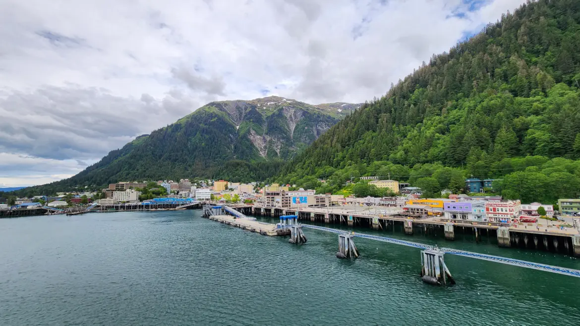 View of downtown Juneau and the cruise port with mountains rising behind, seen from the water in Alaska