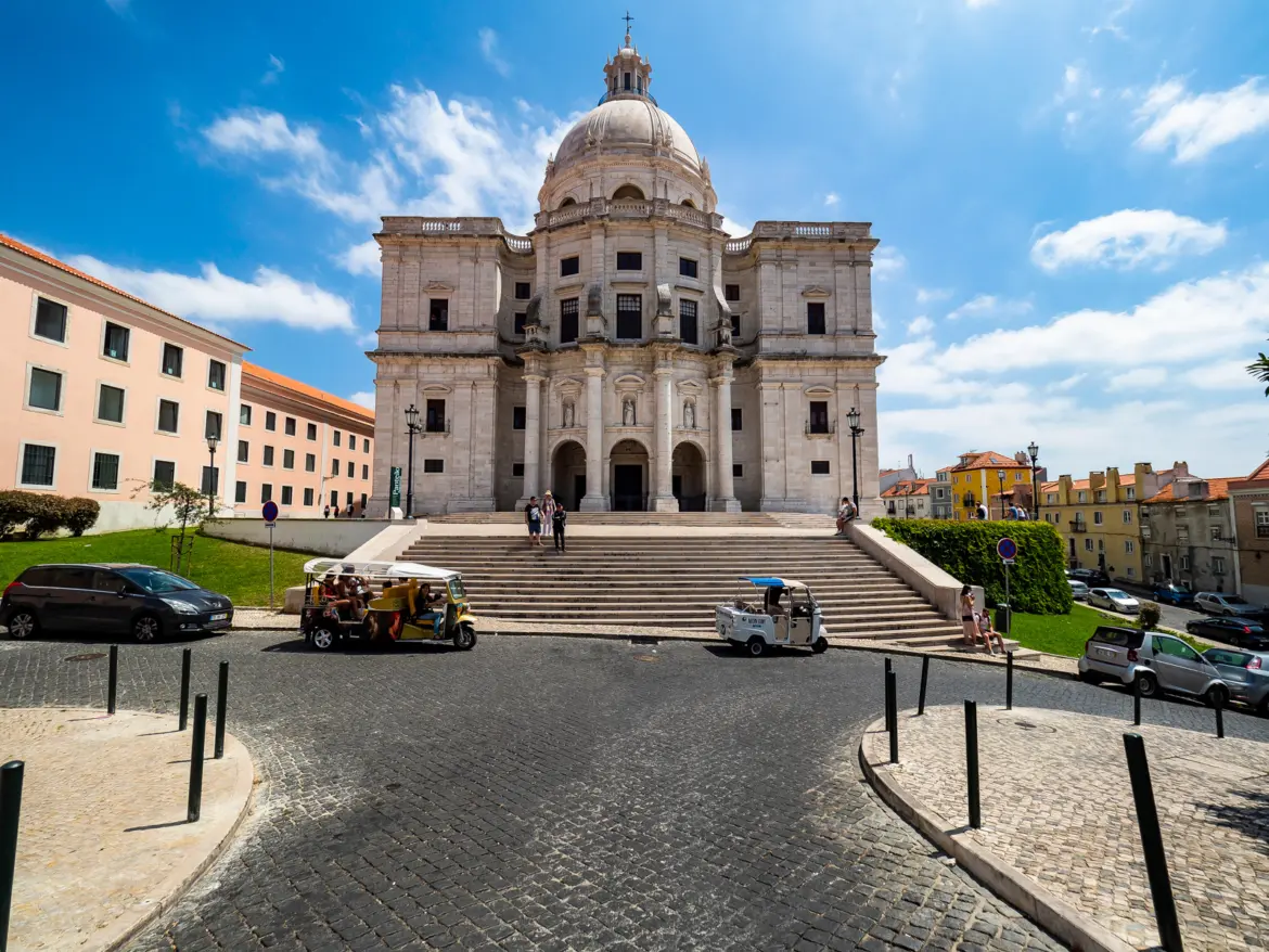 Exterior façade of the National Pantheon in Alfama Lisbon with white dome grand steps and tuk-tuks on a sunny day