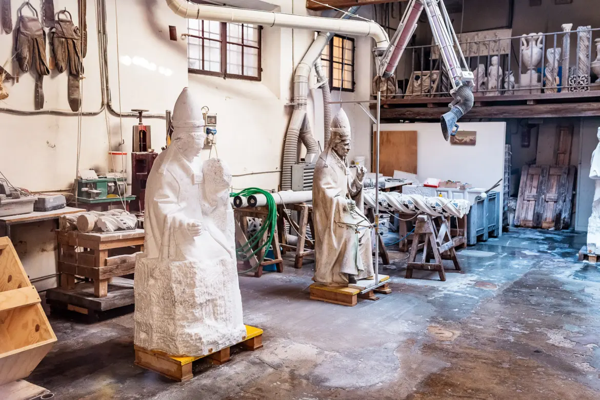 Traditional artisan workshop in Florence’s Oltrarno district where craftsmen restore medieval statues and historic sculptures