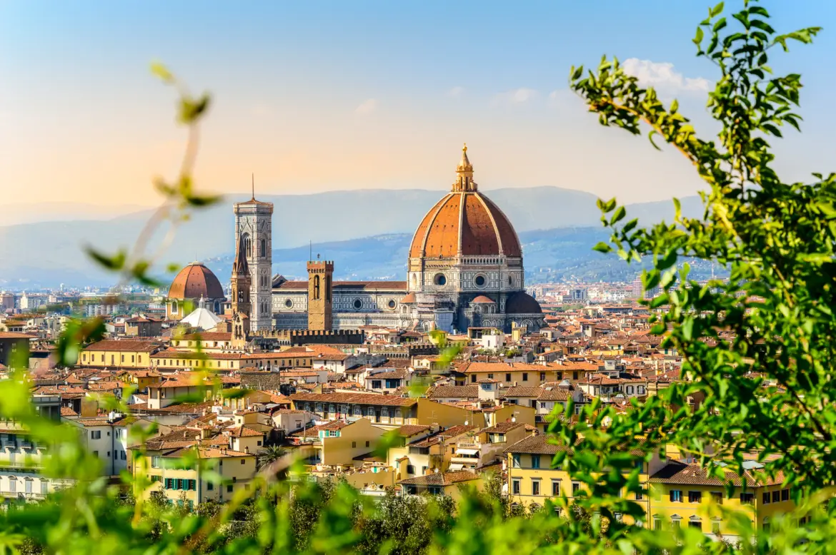 Florence skyline featuring the iconic Duomo and Giotto’s Bell Tower rising above terracotta rooftops in a panoramic view of the Renaissance city