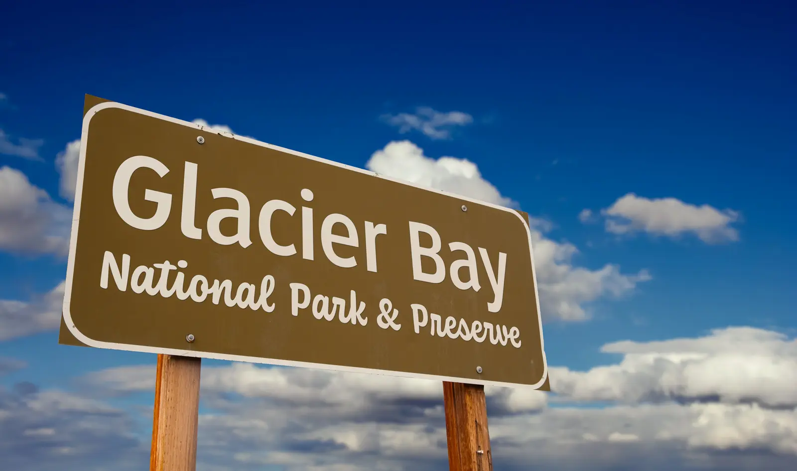 Glacier Bay National Park and Preserve entrance sign set against a blue sky in Alaska