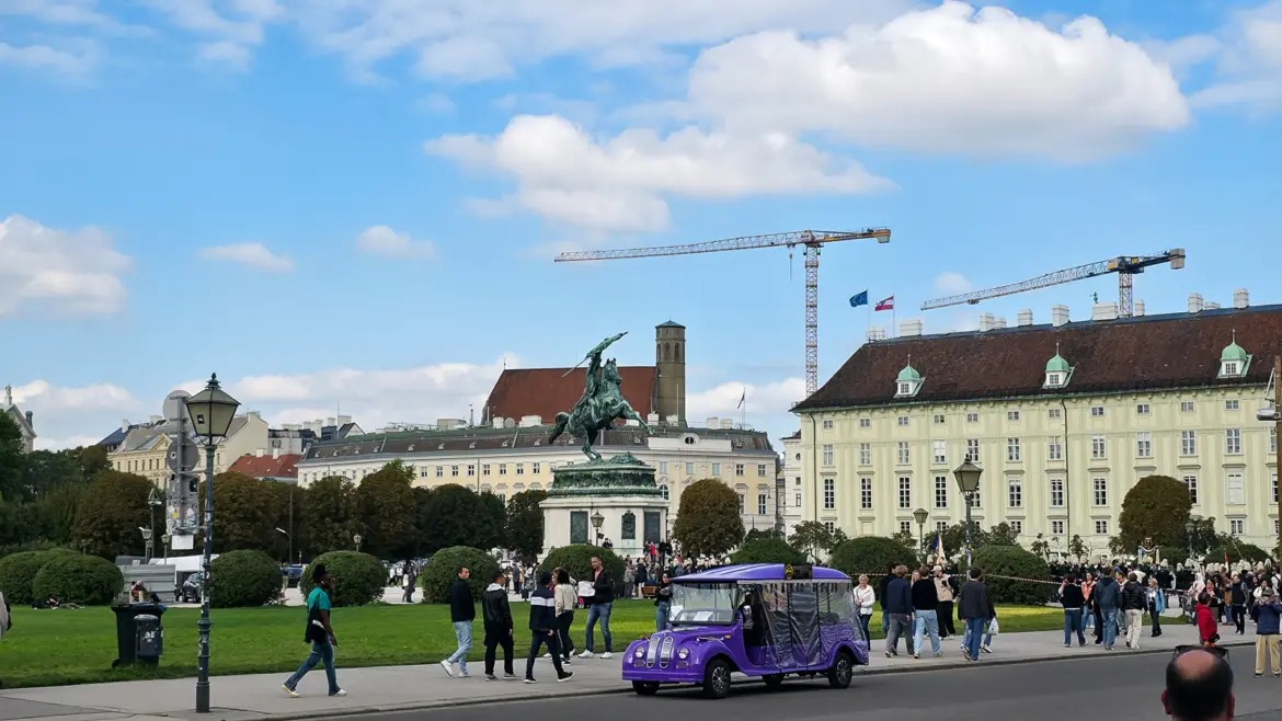 Visitors walking through Heldenplatz near the equestrian statue of Archduke Charles, where centuries of imperial history meet the everyday rhythm of modern Vienna