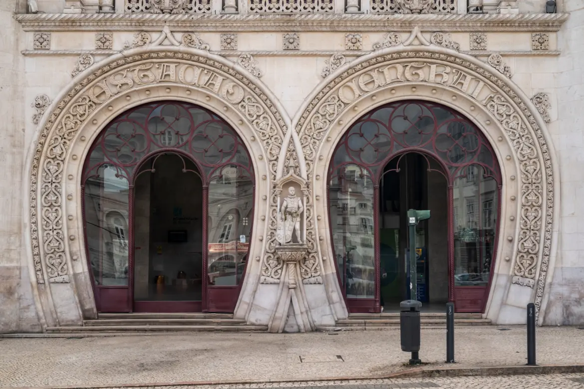 Close-up of the iconic horseshoe-shaped arches at the entrance to Rossio Station in Lisbon with intricate Neo-Manueline stonework and carved maritime motifs