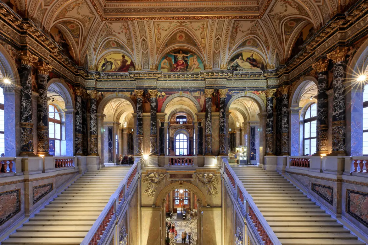 Decorative paintings by Gustav Klimt integrated into the grand staircase arches at the Kunsthistorisches Museum in Vienna
