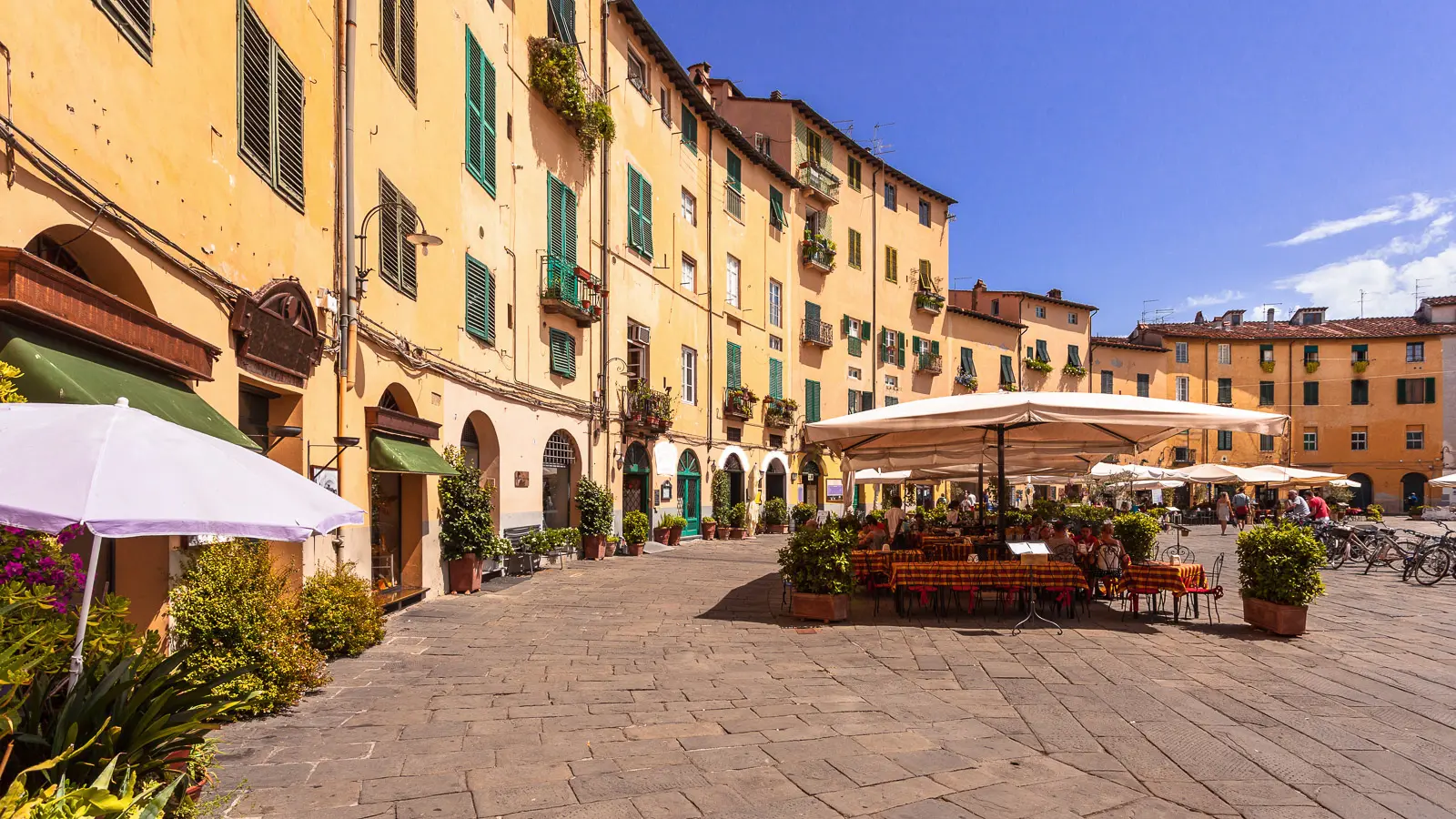 Outdoor cafés and restaurants in Piazza dell’Anfiteatro in Lucca, a unique oval-shaped square built on the remains of a Roman amphitheatre