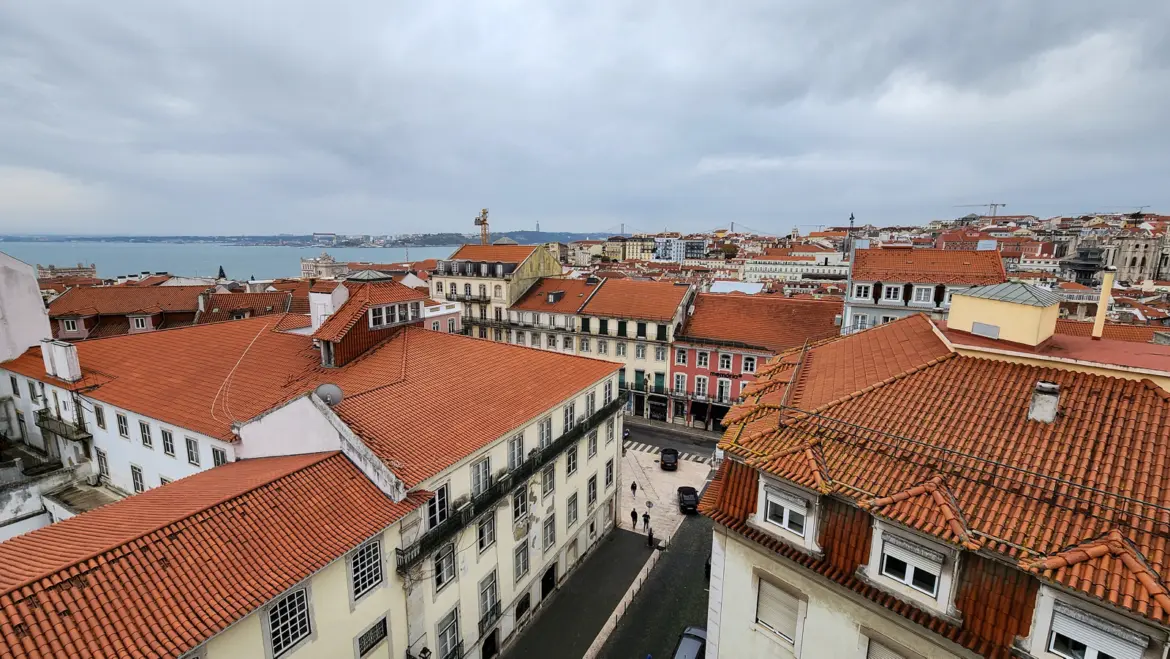Aerial view of the Pombaline grid layout in Lisbon's Baixa district with red rooftops and the Tagus River