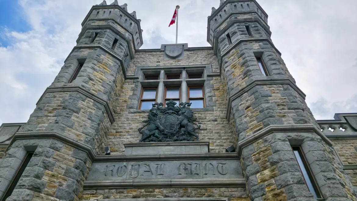 Close-up of the Royal Canadian Mint façade in Ottawa showing the château-style towers, limestone exterior, and Royal Mint coat of arms