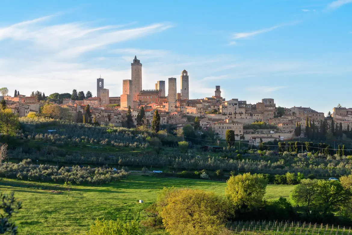 San Gimignano skyline with its iconic medieval towers rising above vineyards and the rolling Tuscan countryside