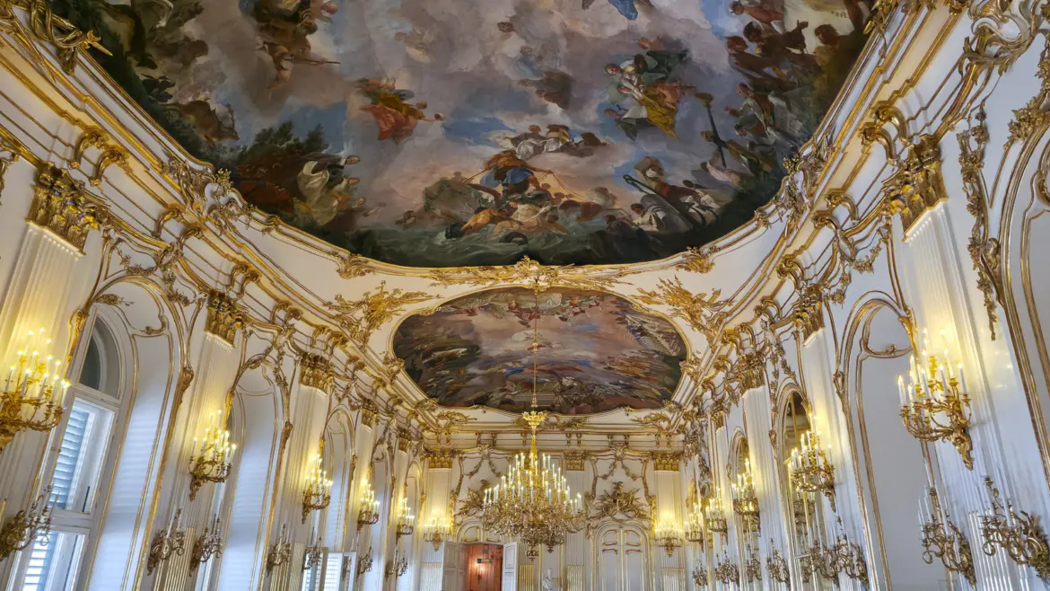 The gilded Rococo ornamentation, frescoed ceiling, and crystal chandelier in the Great Gallery of Schönbrunn Palace in Vienna, one of the most magnificent ceremonial halls