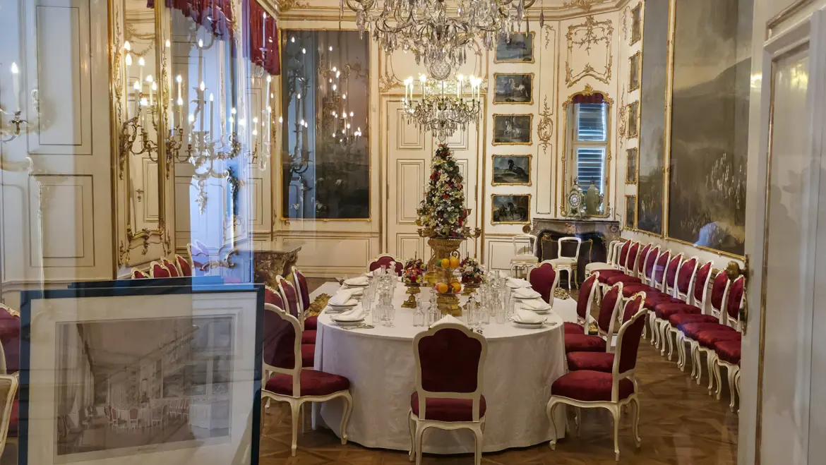 Ornate imperial dining room at Schönbrunn Palace in Vienna, preserved behind glass as part of the Habsburg palace interiors