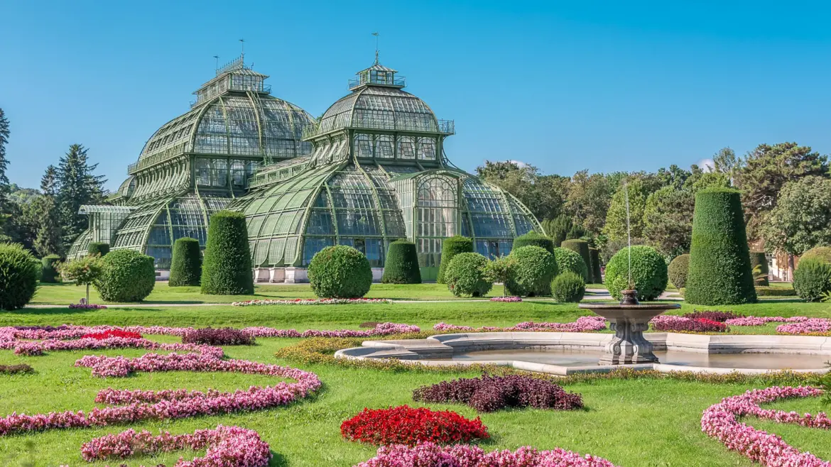 The historic Palm House greenhouse at Schönbrunn Palace in Vienna, one of the largest historic greenhouses in Europe, surrounded by formal gardens