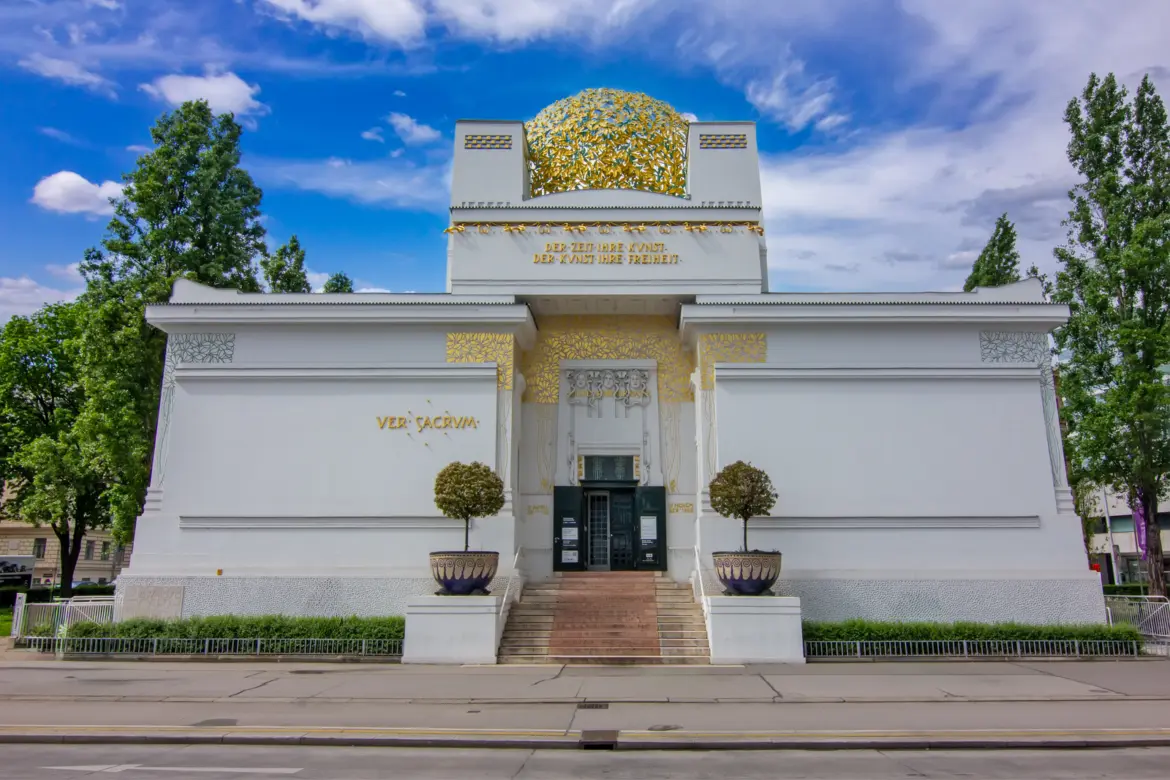 Entrance façade of the Secession Building in Vienna featuring its iconic white architecture, golden dome, and Ver Sacrum inscription