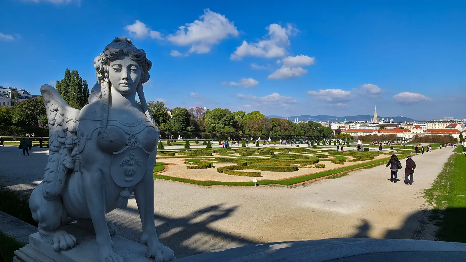 A sculpted sphinx in the Belvedere Gardens in Vienna surrounded by manicured Baroque landscaping