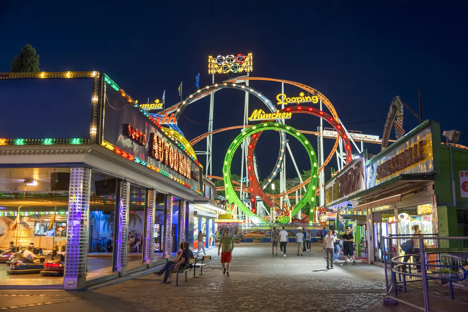 The Wurstelprater amusement park in Vienna illuminated at night with colorful rides and lively crowds
