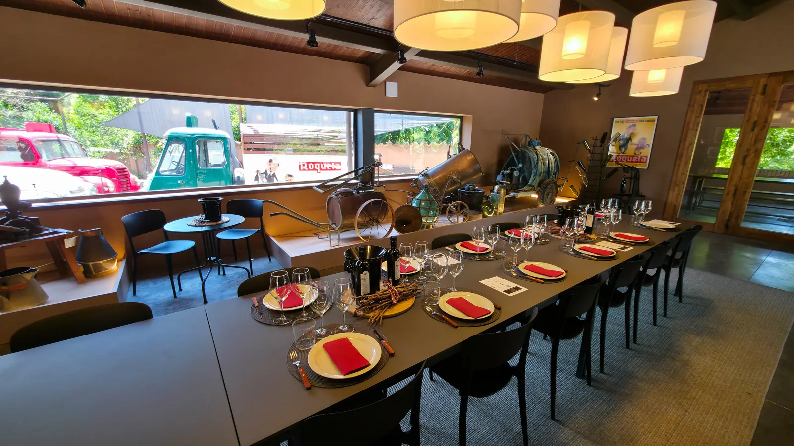 Glasses of Abadal wine sparkling like jewels in the afternoon sun at a rustic wooden table overlooking the vineyards of the Pla de Bages wine region