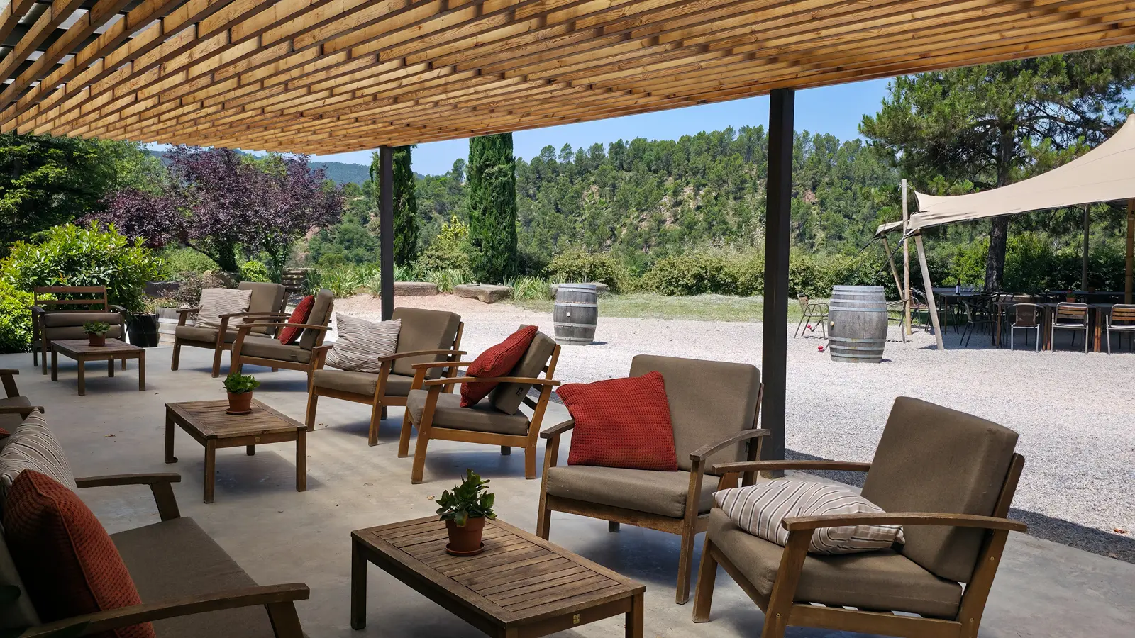 The exterior of Abadal Winery upon arrival, set among the terraced vineyards and forested hills of the Pla de Bages, with the warm Catalan afternoon light softening across the estate