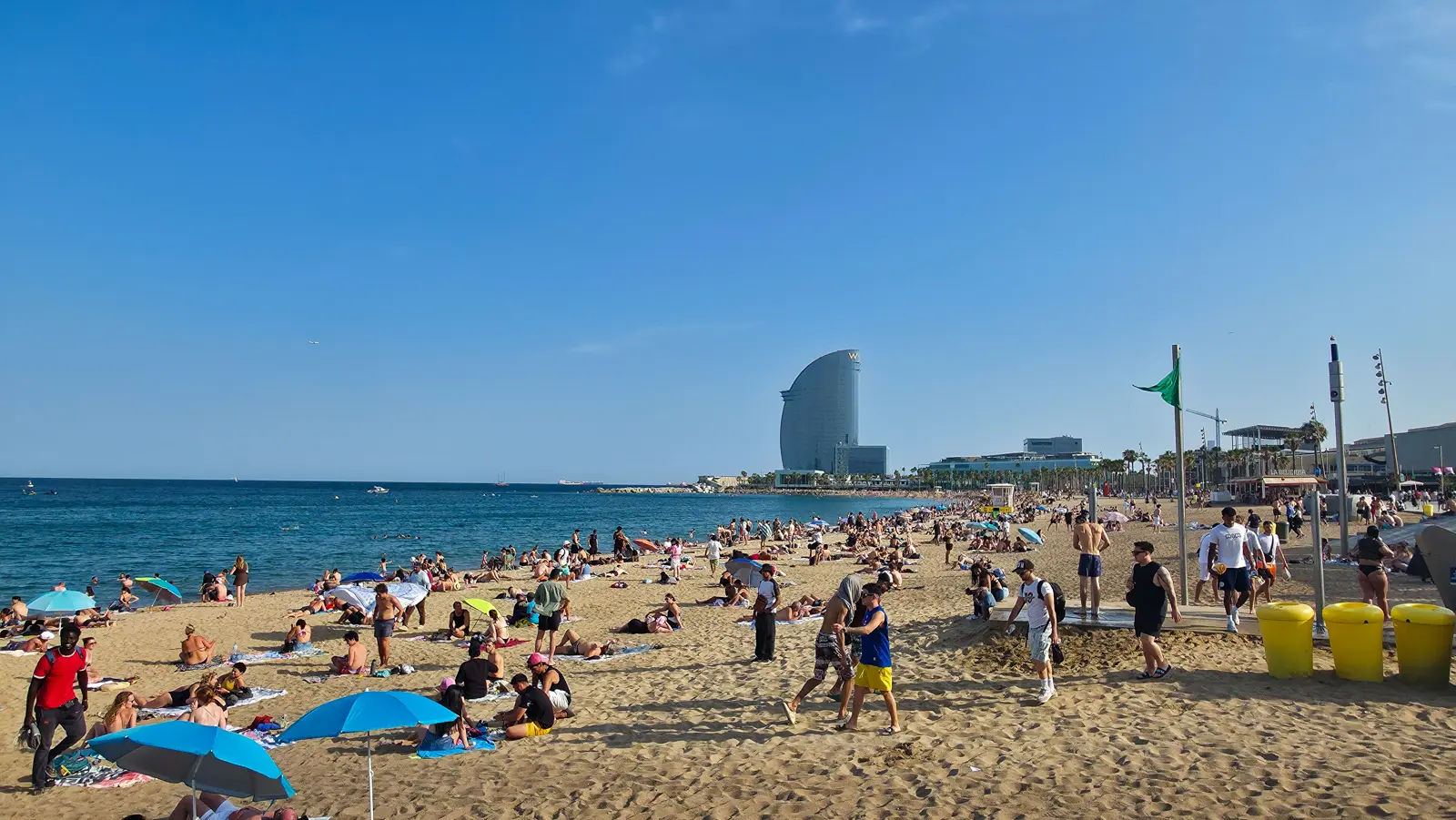 Barceloneta Beach with the sail-shaped W Barcelona Hotel rising at the edge of the water in golden afternoon light