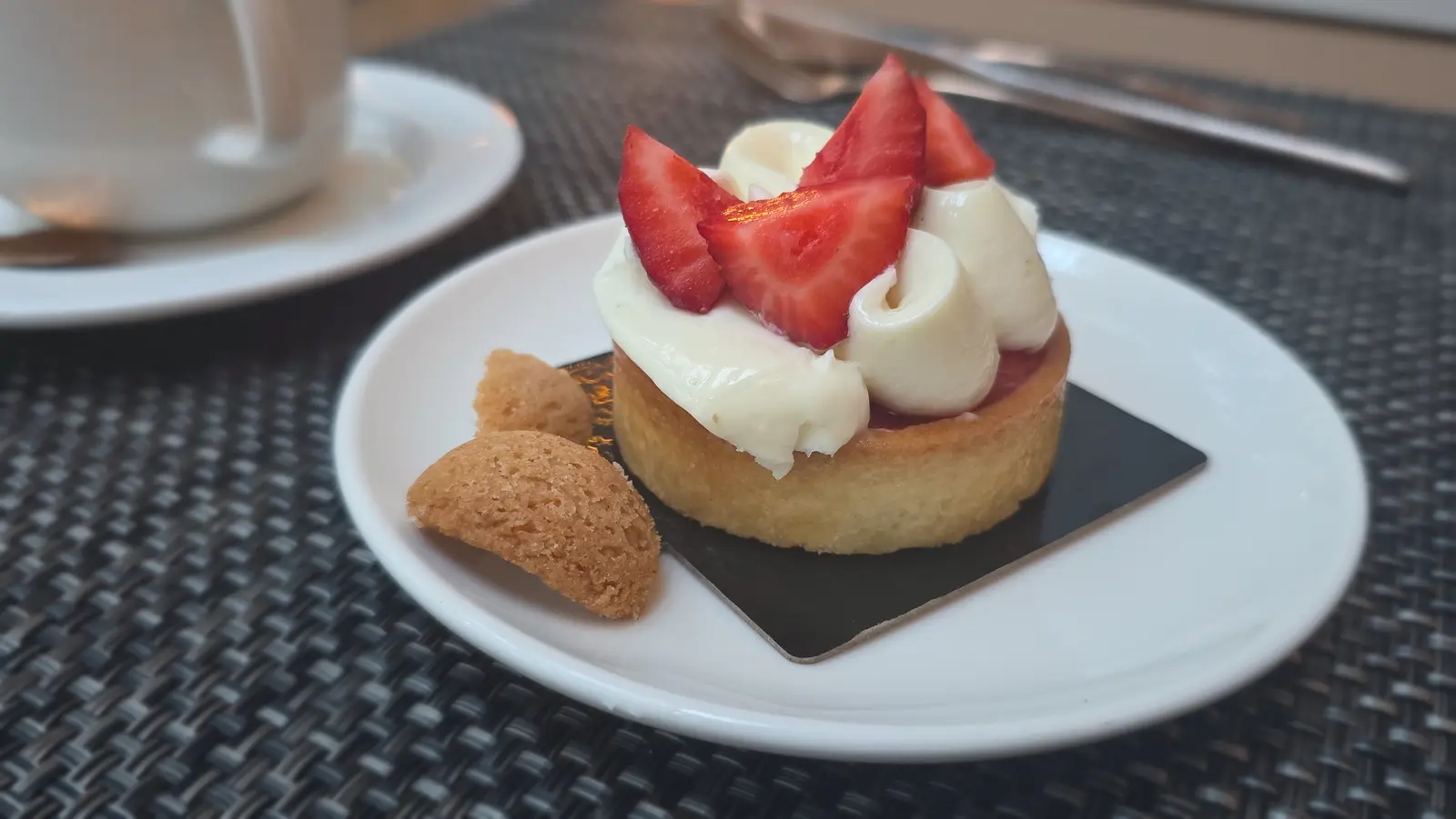 A delicate strawberry tart at Blanc, Mandarin Oriental Barcelona — thin crisp pastry layered with ripe strawberries glazed just enough to catch the light from the glass atrium above