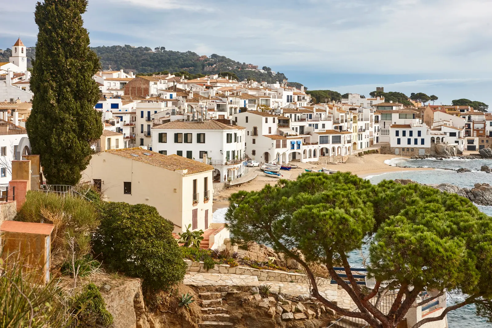 The whitewashed houses of Calella de Palafrugell perched above the turquoise Mediterranean on the Costa Brava, one of Catalonia's most charming and photogenic fishing villages