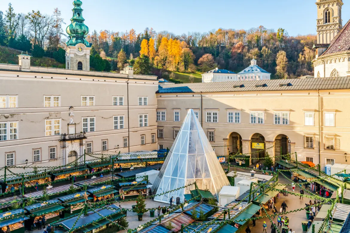 Elevated view of the Salzburg Christkindlmarkt with decorated stalls and a central illuminated pyramid, Austria