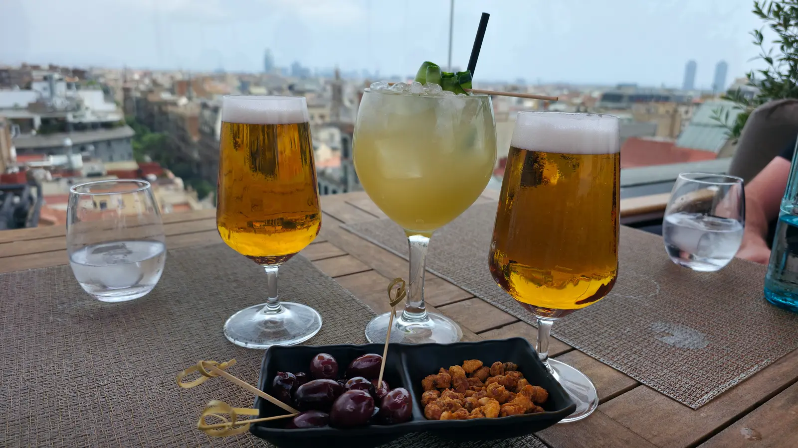 Refreshing drinks at La Dolce Vitae rooftop bar at the Majestic Hotel Barcelona — a crisp beer and the Fresh Cooler cocktail with cucumber, ginger, pineapple, and cinnamon syrup