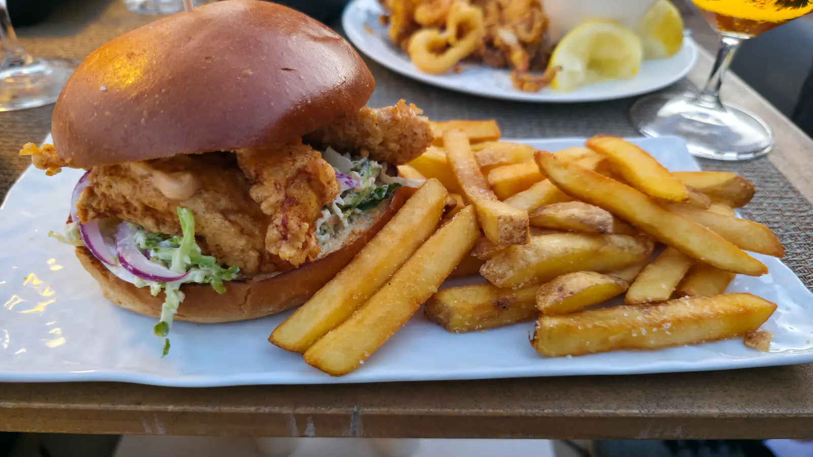 Spicy fried chicken sandwich with smoked sriracha and coleslaw at La Dolce Vitae rooftop, Majestic Hotel Barcelona — juicy, smoky, and satisfying with a cool crisp slaw balance