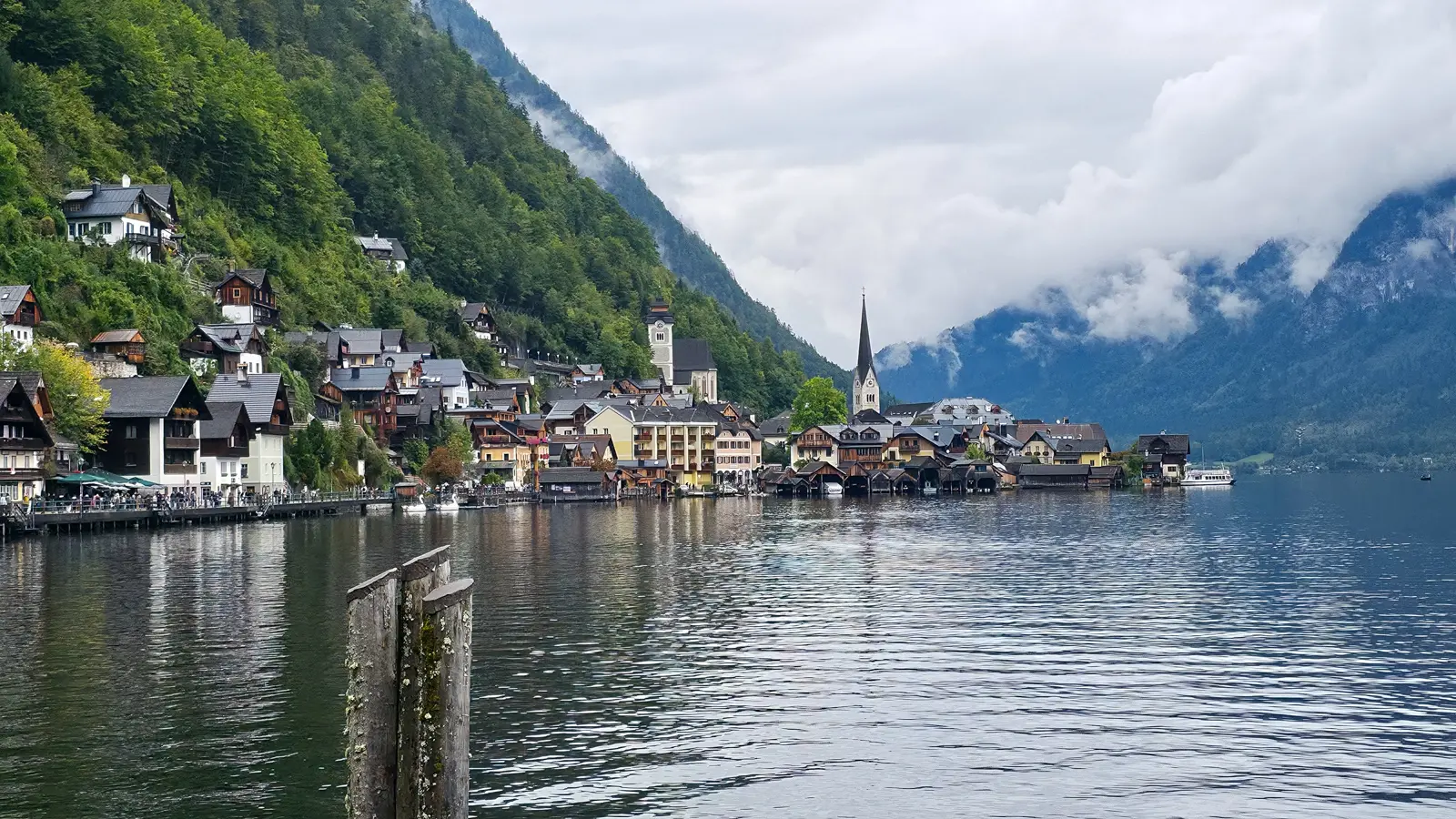 Evangelische Pfarrkirche Hallstatt seen from across Lake Hallstatt, with its spire reflected in the water forming the village's iconic postcard image