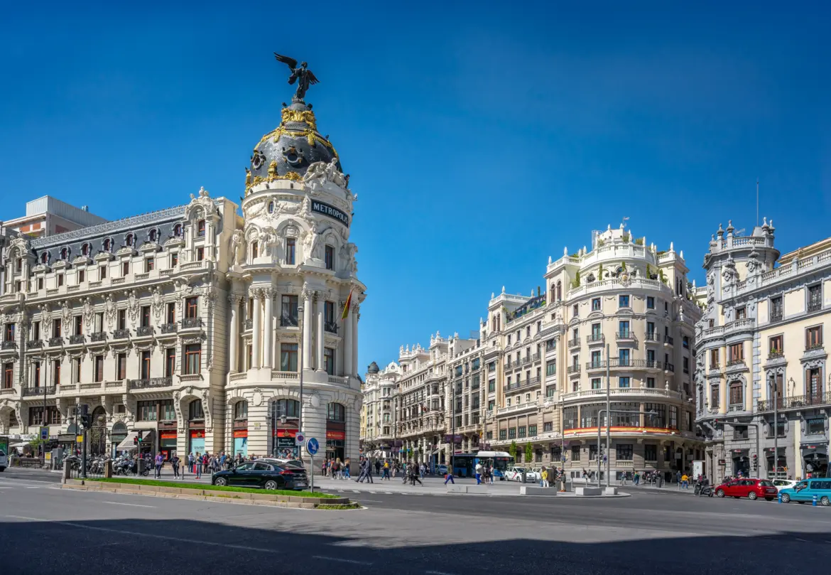 Gran Vía in Madrid with the iconic Edificio Metrópolis and its golden dome, capturing the boulevard's grand scale and early 20th-century architecture