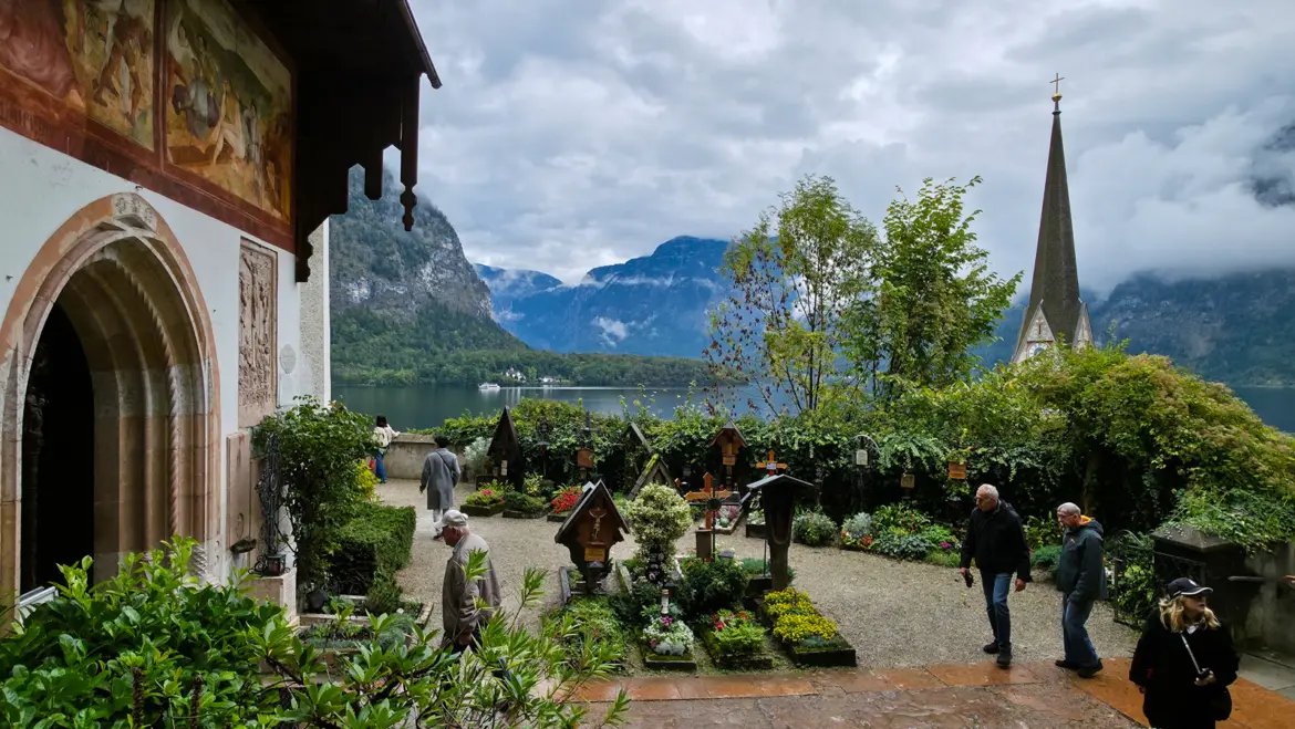 Hallstatt cemetery above the village, with floral graves, wrought iron crosses, and views over Lake Hallstatt and the alpine landscape