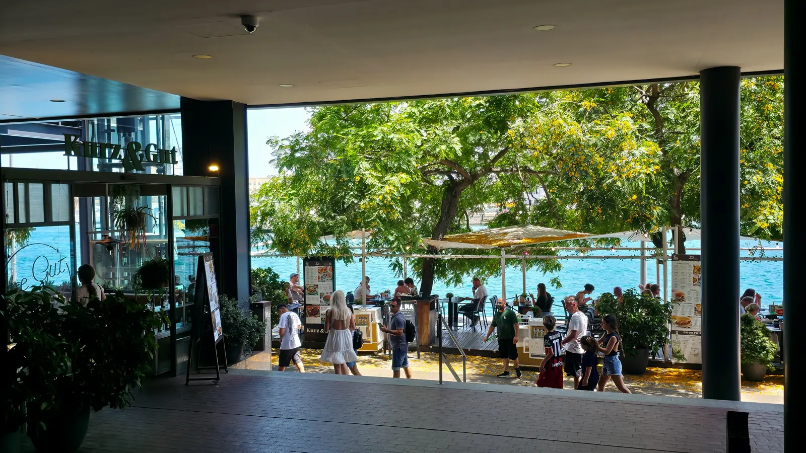 Wooden deck and terrace ambience at Kurz & Gut Maremagnum in Barcelona on a sunlit afternoon