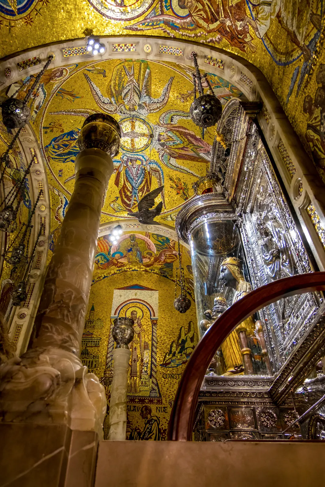 La Moreneta, the Black Madonna of Montserrat, in close-up detail — her serene expression, the gilded throne, and the sphere in her right hand that visitors gently touch as they pass