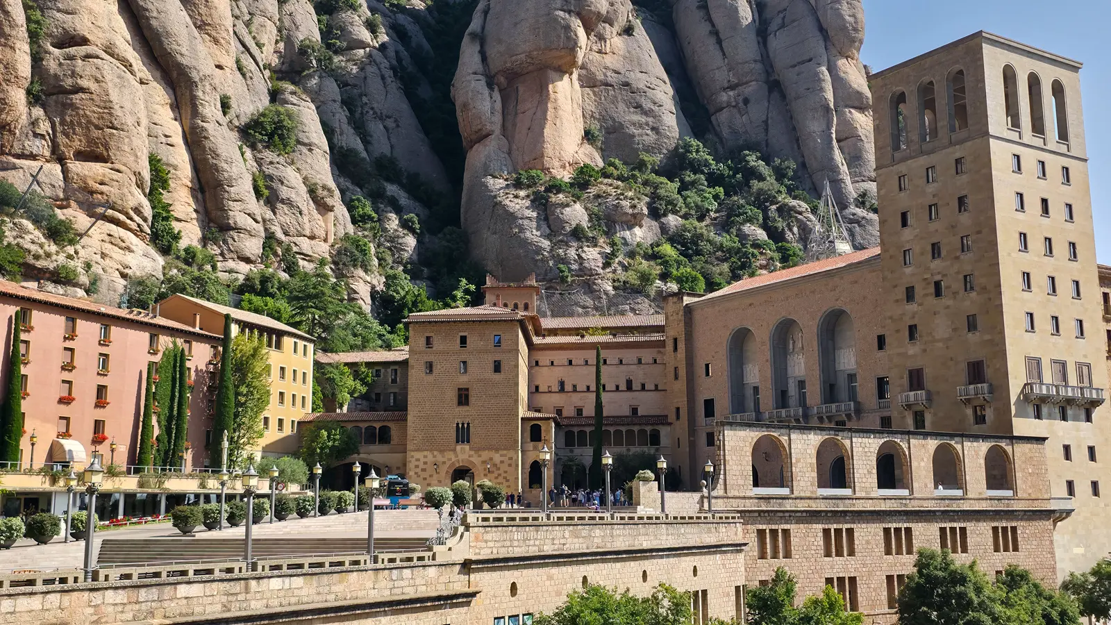 The monastery of Santa Maria de Montserrat perched against the dramatic serrated mountain peaks, a mountaintop sanctuary of faith and ancient wisdom featured in Dan Brown's Origin