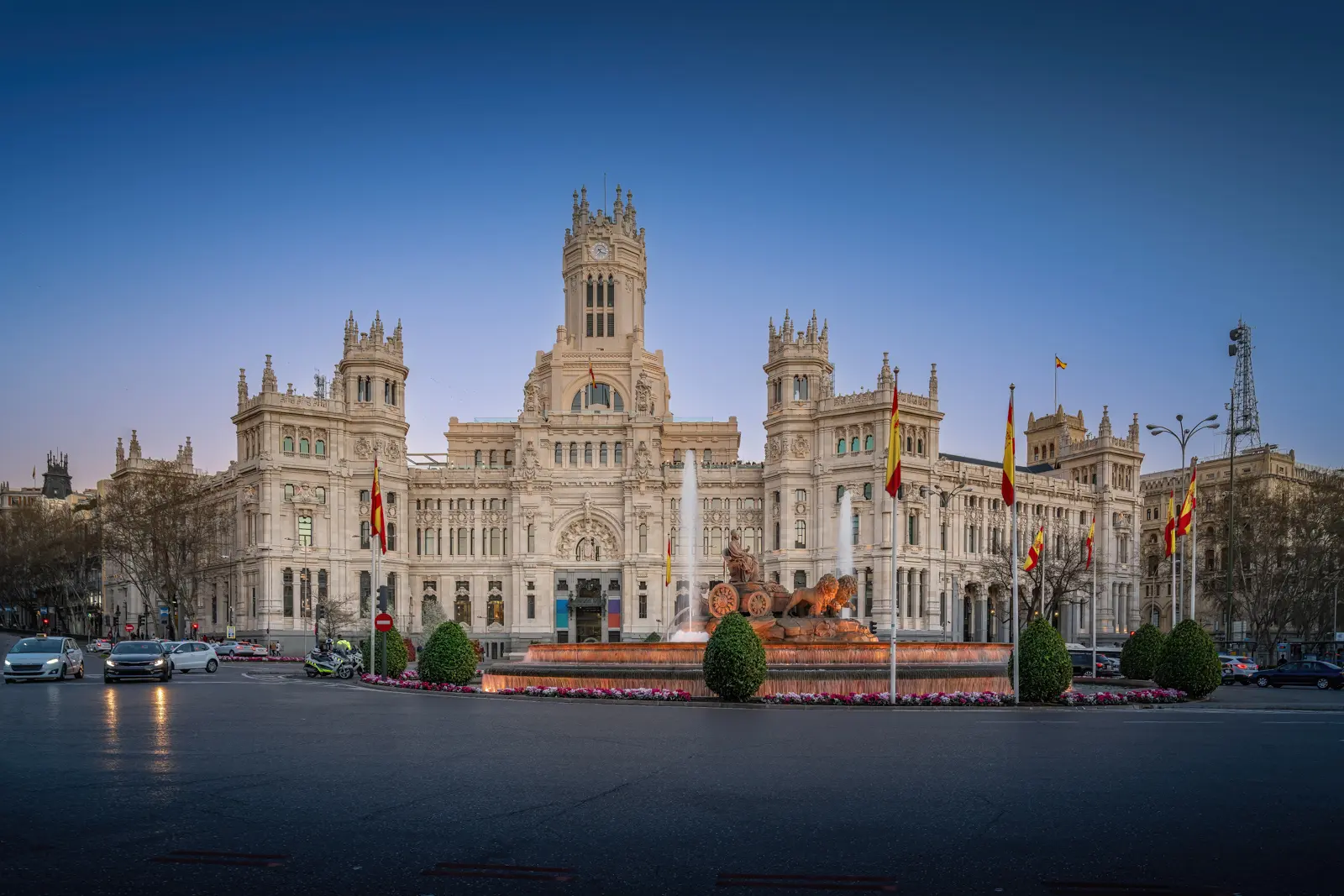 Plaza de Cibeles at golden hour in Madrid with warm light on white marble buildings and the fountain