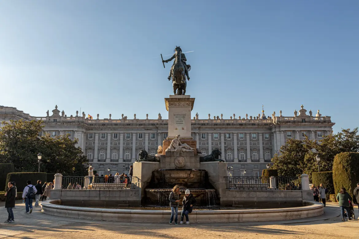 Plaza de Oriente in Madrid with the Royal Palace gardens king statues and visitors on a sunny day