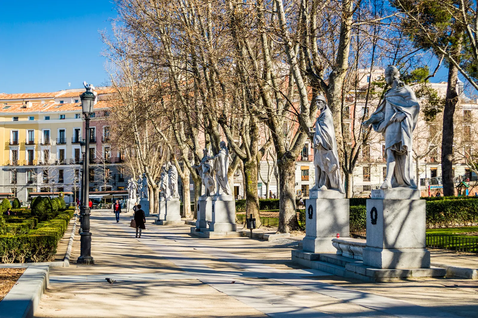 Plaza de Oriente gardens in Madrid with trees hedges and the Royal Palace in the background