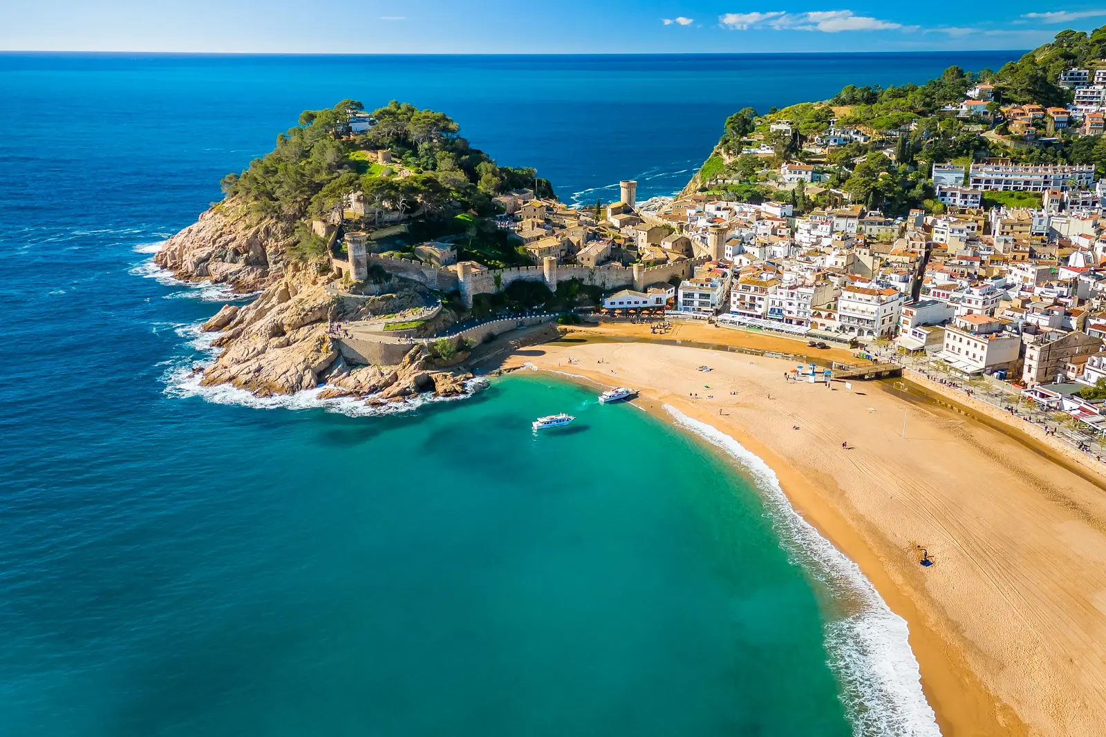 The medieval walled old town of Tossa de Mar rising above a turquoise cove on the Costa Brava, one of Catalonia's most scenic and dramatic coastal landscapes