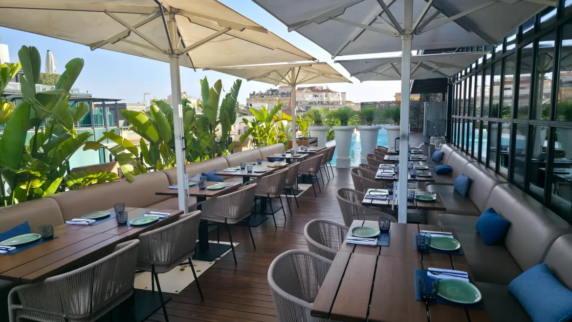 Verbena Terrace Rooftop at the Monument Hotel on Passeig de Gràcia in Barcelona, with Mediterranean greenery, sleek lounge seating, and sweeping views over the Eixample district rooftops