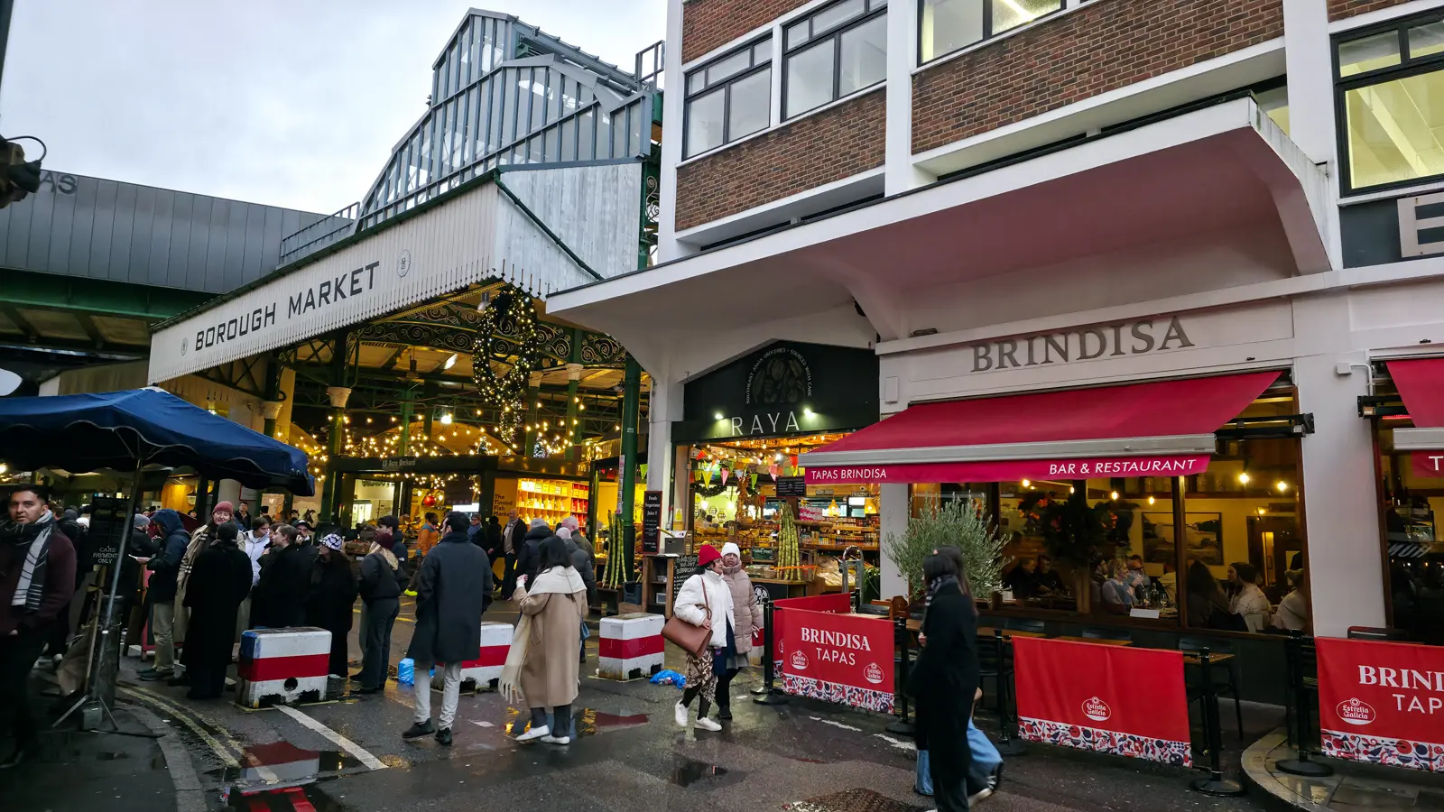 The Brindisa Tapas Bar & Restaurant on Bedale Street beside the main Borough Market entrance, with the red Brindisa awning beside the market's wrought-iron arches